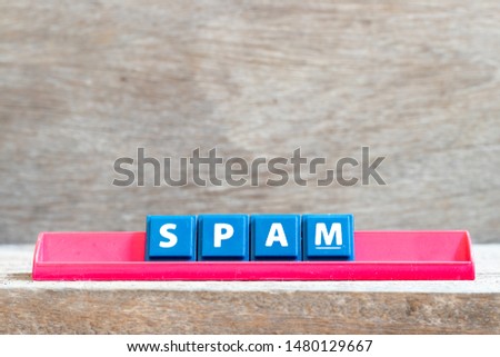 Tile letter on red rack in word spam on wood background