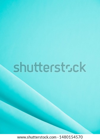 Smooth elegant wavy turquoise silk or satin luxury cloth fabric texture, abstract background design.