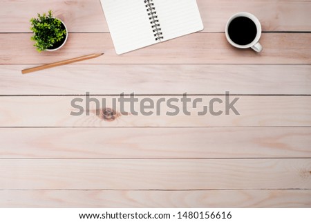Work space brown wooden office table desk with blank notepad and coffee cup, leave and supplies, flat lay, top view with copy space