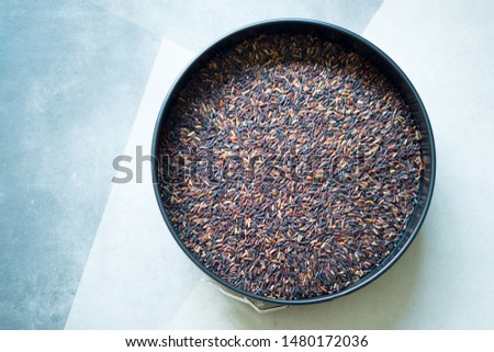 Thai black Jasmine rice or Riceberry organic food in black bowl