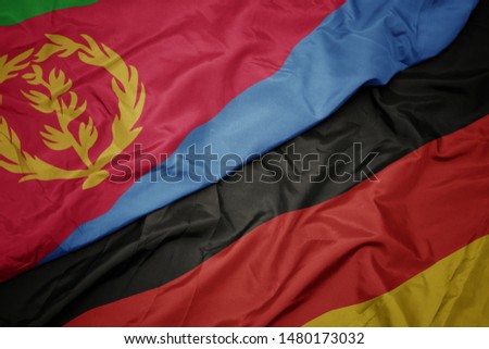 waving colorful flag of germany and national flag of eritrea. macro
