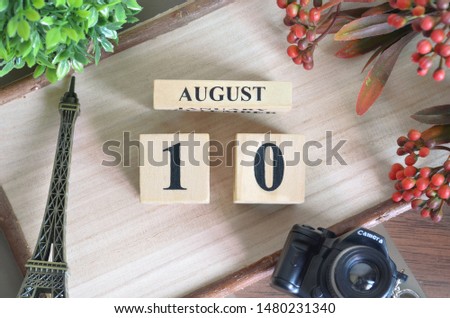 August 10. Date of August month. Number Cube with a flower camera and Sign wood on Diamond wood table for the background.