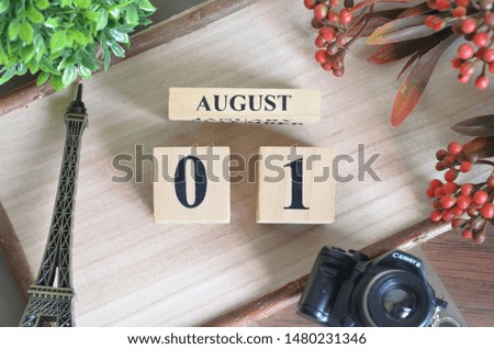 August 1. Date of August month. Number Cube with a flower camera and Sign wood on Diamond wood table for the background.