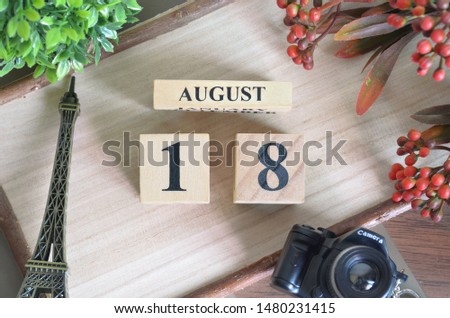 August 18. Date of August month. Number Cube with a flower camera and Sign wood on Diamond wood table for the background.