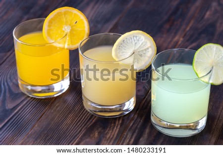 Assortment of citrus juices on the wooden background