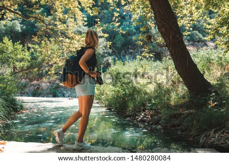 Young Caucasian woman photographer shooting in the forest. Nature photographer concept.