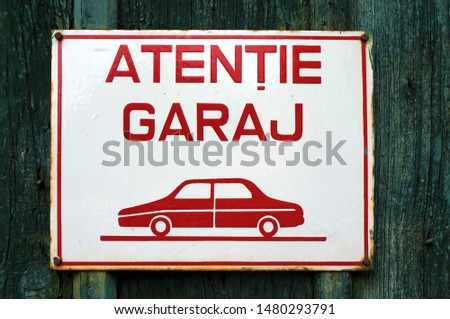 Metal sign with a warning to not block the garage door in Medias, Romania. Text in Romanian. 