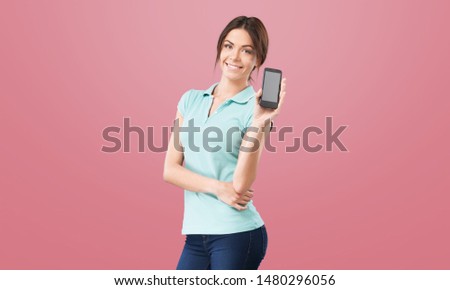 Beautiful young woman chatting by mobile phone over pink wall background