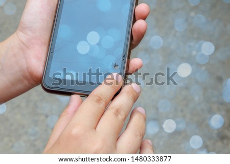 Broken phone in male hands. Broken sensor, crack on the screen, close-up. Bokeh effect.