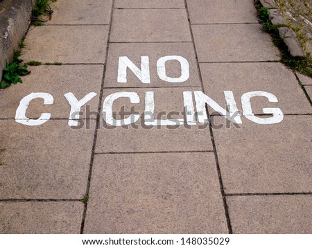 A "No Cycling" warning on a sidewalk (pavement), a common sight in more pedestrianized areas. Horizontal format with copy space.