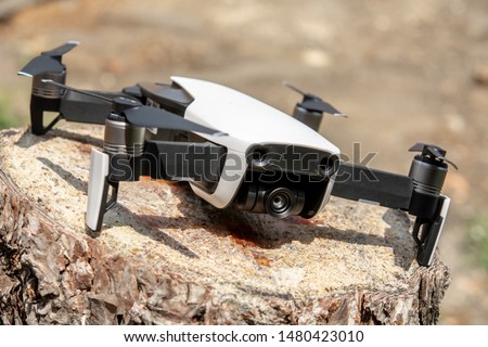Foldable professional drone with camera sitting on the wood