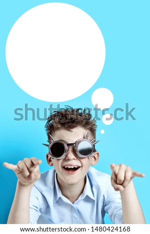 rocker boy in blue shirt and biker glasses on light blue background