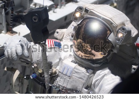 The astronaut in a space suit, in an outer space, is engaged in repair of the space station. Elements of this image were furnished by NASA