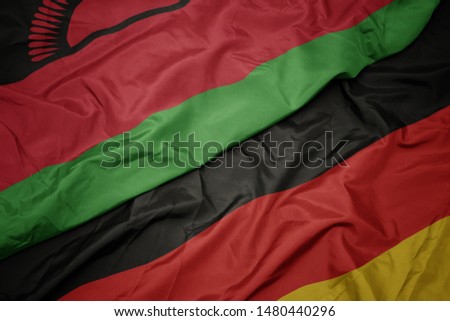 waving colorful flag of germany and national flag of malawi. macro