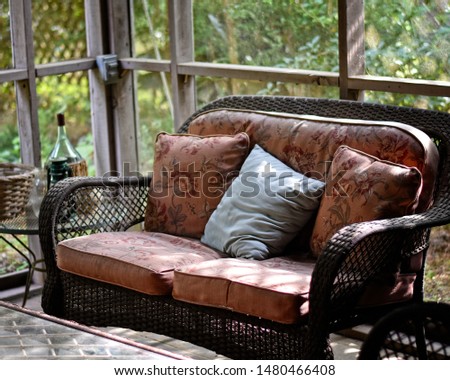 wicker sofa on screened porch in afternoon sun