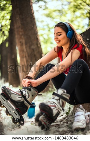 Good looking girl prepare for rollerblading in the city park