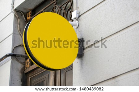 round blank signboard hanging on wall and Photo blank yellow mockup of street store vintage signboard on an old yellow brick wall