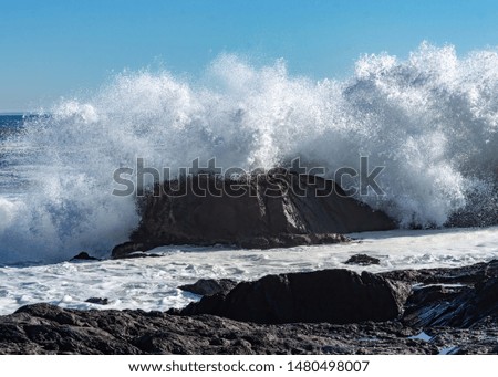 Waves crashing against the rocks.