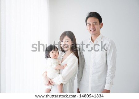 Parents and baby standing by the window