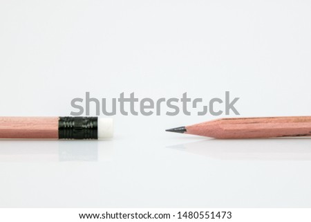 Sharp pencil against eraser end on white background