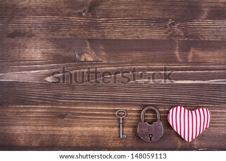 Heart, key and lock on vintage wood background