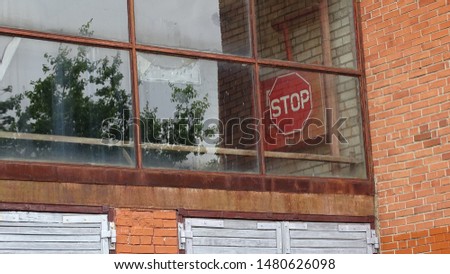 Stop sign behind a windows in garage building bricks