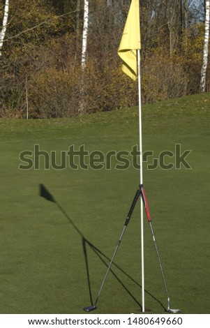Golfclubs with flag making a shadow