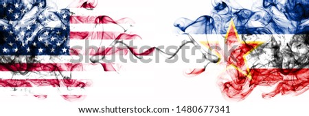 United States of America vs Yugoslavia smoky mystic flags placed side by side. Thick colored silky abstract smokes banner of America and Yugoslavia