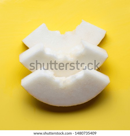 Melon sliced on yellow background. Flat lay. Food concept. Trendy color Illuminating of the 2021 year.