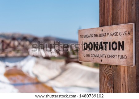Sign asking visitors to donate to a charity if they wish to take a boat ride