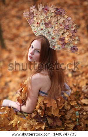 Portrait of beautiful red haired Woman, Fall Leaves Dress, Beauty Girl in the autumn park