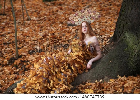 Portrait of beautiful red haired Woman, Fall Leaves Dress, Beauty Girl in the autumn park