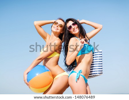 summer holidays, vacation and beach activities - girls with ball on the beach