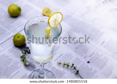 A glass of chilled lemonade with lemons and grass. Best drink to lose weight and gain energy.