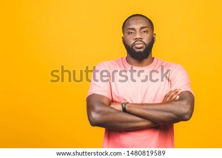 Thinking black Afro American man with serious expression looking, posing isolated against yellow background. 