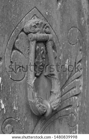 Decoration elements of buildings, antique iron doorknobs, keyhole, knockers and gong handle. Black and white retro style photo.