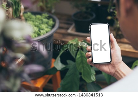 Mockup image blank screen cell phone.woman hand holding texting using mobile at outdoor area in home.white empty space advertise text. contact business,people communication,technology device concept