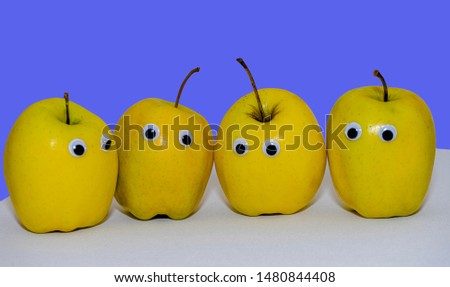 several yellow apples with eyes
