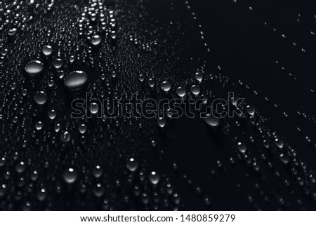 Water drops on smooth surface, black background