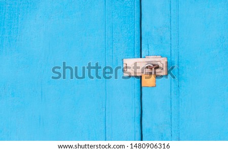 Golden padlock on old blue wooden door. The keys is on the sky blue wooden floor, along with the empty space, enter the text.