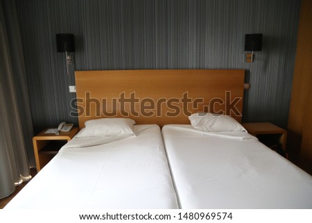 Fatima, Europe / Portugal - June 2018:Double bed with two mattresses, lamps and gray curtains in the hotel room Royalty-Free Stock Photo #1480969574