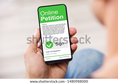 Man Looking At Online Petition Form On Smartphone Royalty-Free Stock Photo #1480988000