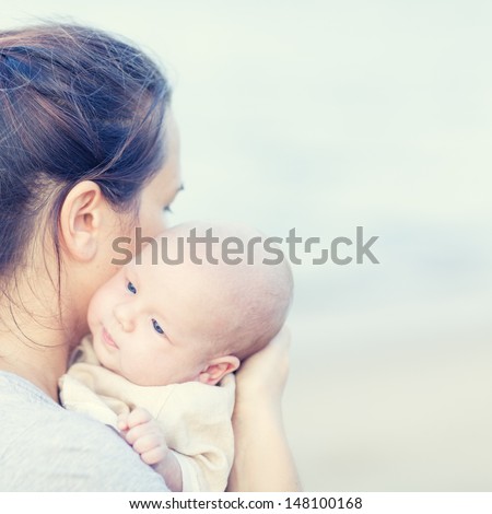 Young mother with baby on the beach