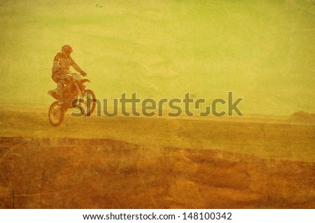 vintage photo of a biker making a stunt and jumps on motorbike