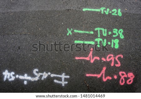 Engineering markings on pavement surface indicating location of subsurface cables Royalty-Free Stock Photo #1481014469