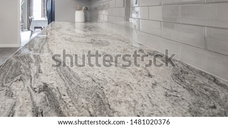 Granite countertop, white and grey tones. grey subway glass tile backsplash, white cookie jar, utensil jar  Royalty-Free Stock Photo #1481020376