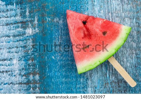 Triangular slices of watermelon on a blue wooden background.