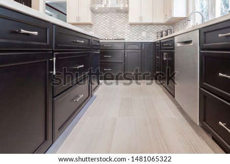 Brown / Espresso and white modern kitchen cabinets with shaker door style and stainless steel appliances with porcelain floors Royalty-Free Stock Photo #1481065322