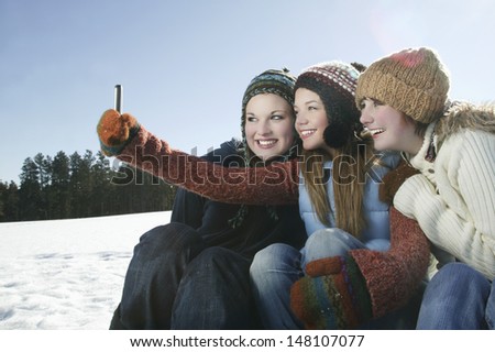 Three female friends taking self portrait in snow