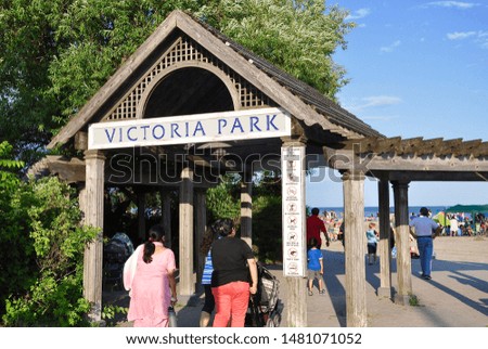 Visitors walk fast below the Victoria park sign.